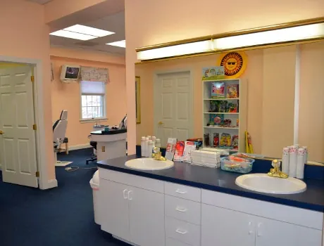 The brushing station at the Hereford office, with sinks and a shelf of toys and games.